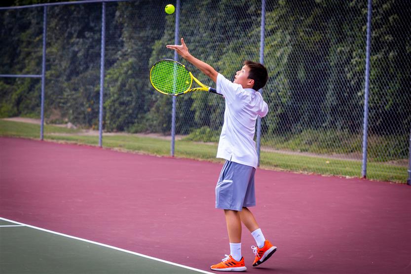 A tennis player serves the ball